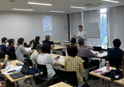 入門講座の様子1。
後ろから撮影。受講者とサポーターが話を聞いている。