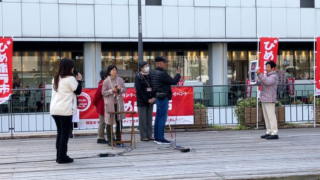 写真　ステージ発表の様子。スマホで信号の色を読み上げているところ